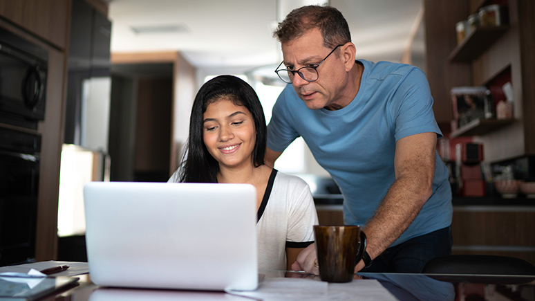 father and daughter looking at a laptop